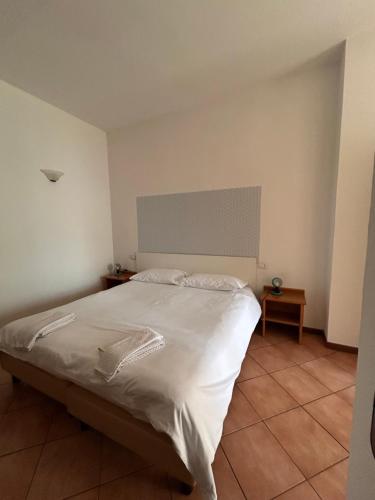 a bedroom with a large bed with white sheets at Casa Miralago in Menaggio