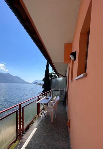 a balcony with a table and chairs next to the water at Miralago Casa in Menaggio