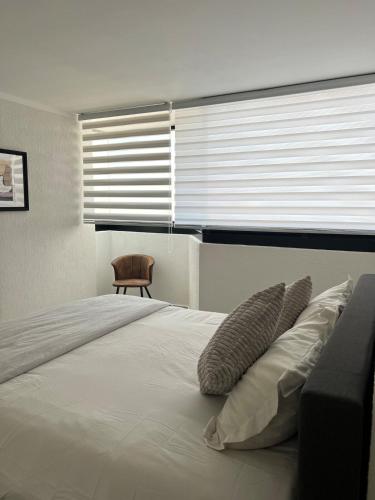 a bedroom with a large bed with pillows and a window at 3 - Departamento amplio y centrico in Morelia