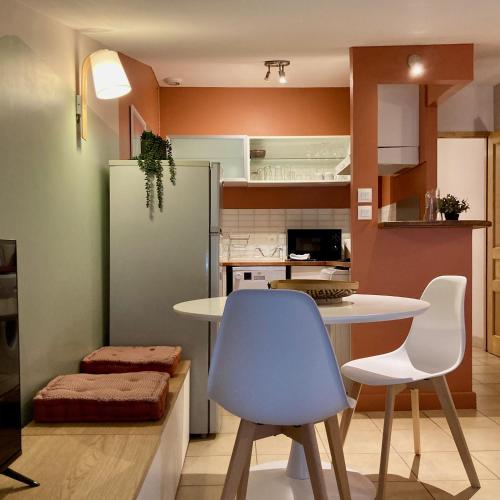 La cuisine est équipée d'une table, de deux chaises et d'un réfrigérateur. dans l'établissement L'Escale médiévale, à Carcassonne