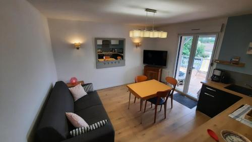 un salon avec un canapé et une table dans l'établissement L'appartement Verdalle, proche de la plage de La Hume, à Gujan-Mestras