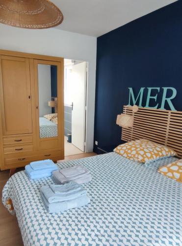 une chambre avec un lit avec un mur bleu dans l'établissement L'appartement Verdalle, proche de la plage de La Hume, à Gujan-Mestras