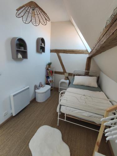une chambre avec un lit dans un grenier dans l'établissement Charmante maison alsacienne, sauna et jardin, à Châtenois