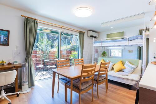 a dining room and living room with a table and chairs at 朝食付きGuest House Fu-ga in Kagoshima