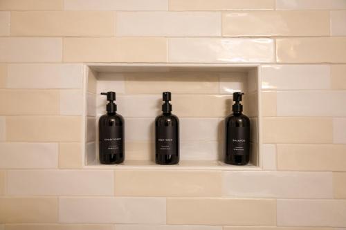 three bottles of wine sitting on a shelf in a wall at Pristine & Homely Getaway with 6pple hot tub in Richardson