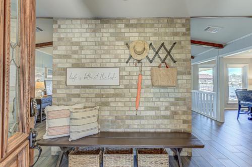 a room with a brick wall with a bench and pillows at Two Docks on Riverside in Kingsland