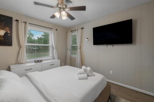 a bedroom with a bed and a flat screen tv at Pristine & Homely Getaway with 6pple hot tub in Richardson