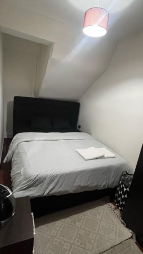 a bedroom with a white bed with a pink light at JM House in Viseu
