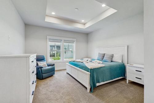 a bedroom with a bed and a blue chair at Stingray Harbor --- 36 Stingray Drive in Ocean View
