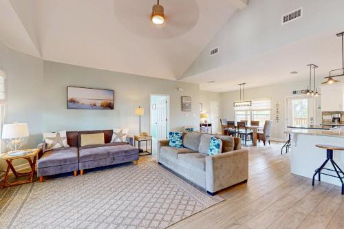 ein Wohnzimmer mit 2 Sofas und einer Küche in der Unterkunft Bale Oasis in Dauphin Island