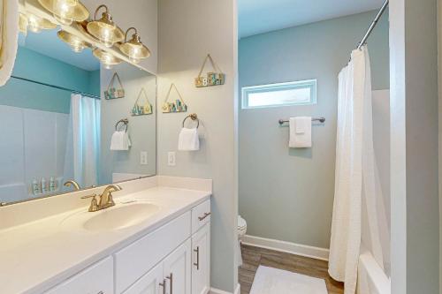 ein Badezimmer mit Waschbecken und Spiegel in der Unterkunft Bale Oasis in Dauphin Island