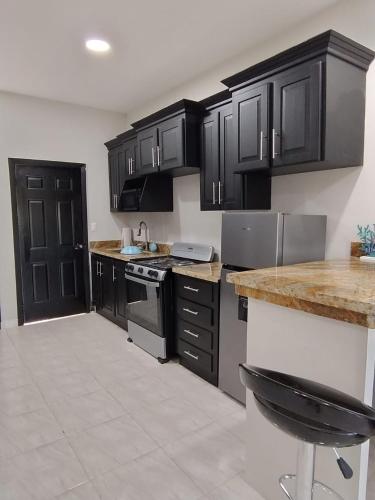 a kitchen with black cabinets and a counter top at Monaco Aparments in La Ceiba
