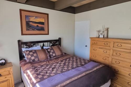 a bedroom with a bed and a wooden dresser at Cozy Lakeside Retreat in South Lake Tahoe