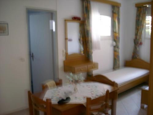 a dining room with a table and chairs and a couch at Xenos Apartments in Keratokampos