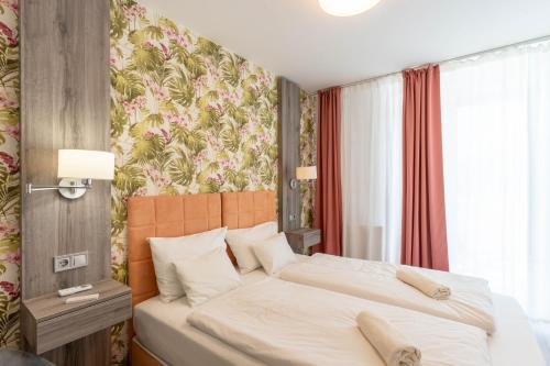 a bedroom with a bed and a floral wallpaper at Sunset Resort 103 in Fonyód