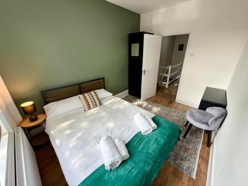 a bedroom with a bed with two towels on it at The Walthamstow Lodge in London