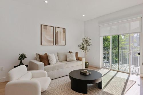 a white living room with a couch and a table at Luxurious 2BR Apartment in heart of Silicon Valley in Santa Clara
