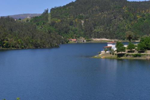a lake with a house in the middle of it at Casa do Vouga in Oliveira de Frades