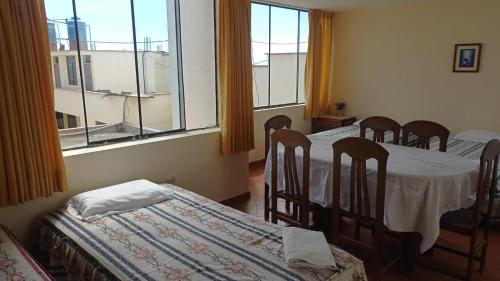 a room with four chairs and a table and windows at Hotel Perseo Inn in Barranca
