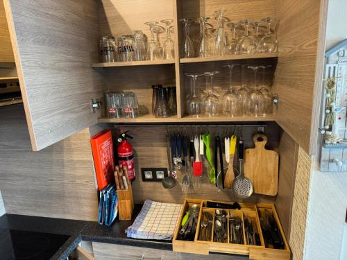 a kitchen with a shelf with glasses and utensils at Splendid Seaview - Ostend Luxury Studio 4 persons at beach and sea in Ostend