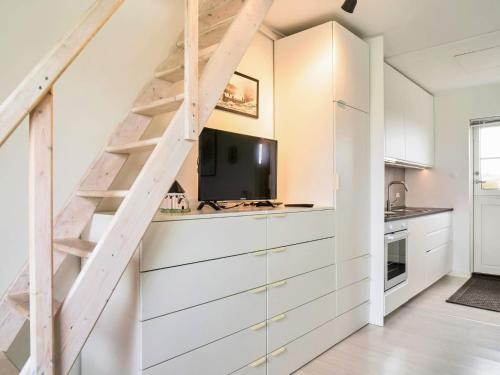 a kitchen with white cabinets and a staircase at Modern Loft with Sea View - By Traum Ferienwohnungen in Allinge