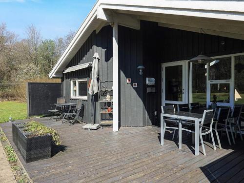 a deck with a table and chairs on a house at 6 person holiday home in Sæby in Sæby