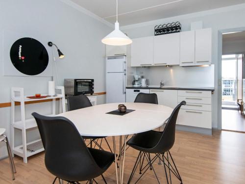 a kitchen and dining room with a white table and chairs at 4 person holiday home on holiday park in Glesborg in Glesborg