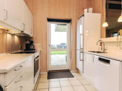 a kitchen with white cabinets and a large window at Well-maintained holiday home in Faborg in Nabbe
