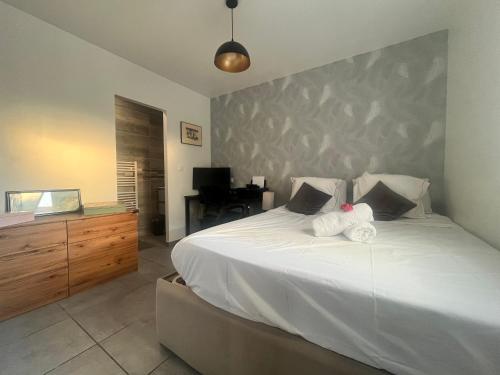 - une chambre avec un grand lit blanc et une commode dans l'établissement Villa familiale avec piscine, jardin,Cosy & calme, à Cournonterral