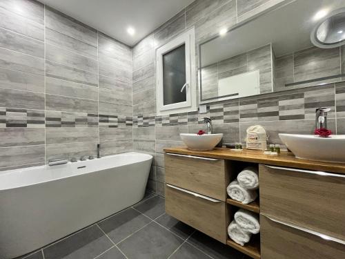 une salle de bain avec deux lavabos et une baignoire dans l'établissement Villa familiale avec piscine, jardin,Cosy & calme, à Cournonterral