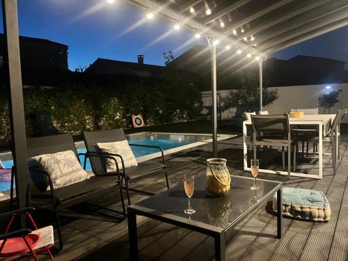 un patio avec une table et des chaises et une piscine dans l'établissement Villa familiale avec piscine, jardin,Cosy & calme, à Cournonterral