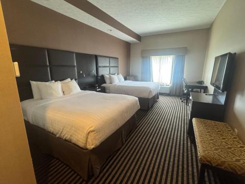 a hotel room with two beds and a television at Sonesta Essential Indianapolis Airport in Plainfield