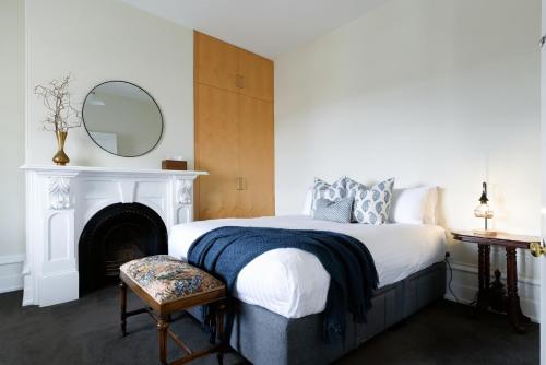 1 dormitorio con 1 cama con chimenea y espejo en Light-Filled Comfort Near Hospital & City, en Kings Park