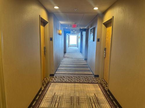 a hallway with a long aisle with blue walls at Sonesta Essential Indianapolis Airport in Plainfield
