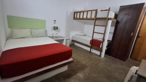 a bedroom with two bunk beds and a ladder at Akas Hotel Apartamentos in Canoas De Punta Sal