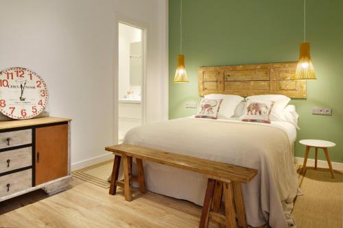 sypialnia z łóżkiem, zegarem i stołem w obiekcie Ambrosse by FeelFree Rentals w mieście San Sebastián