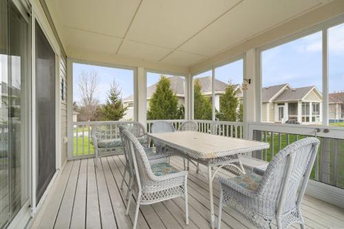a porch with a table and chairs and windows at The Willow - 20 Butternut in Cherry Valley