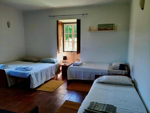ein Zimmer mit zwei Betten und einem Fenster in der Unterkunft Casa dos Limões - Paredes de Coura in Formariz