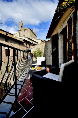 a balcony with a table and chairs and a building at Hotel Volterra In Superior in Volterra