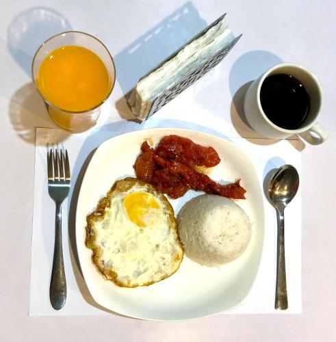 a plate with an egg and bacon and a cup of coffee at Amax Inn Makati in Manila