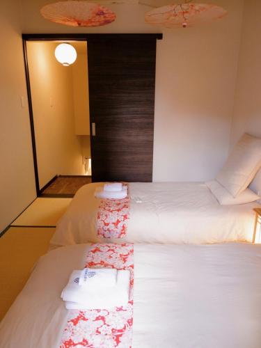 a room with two beds with towels on them at Sannö Sakura House Japanese Entire House with 2 Bedrooms &Near Tennoji 7 min Walk &Near Public Transport Near Abeno Harukas &Direct to Namba Kansai Airport and USJ in Osaka