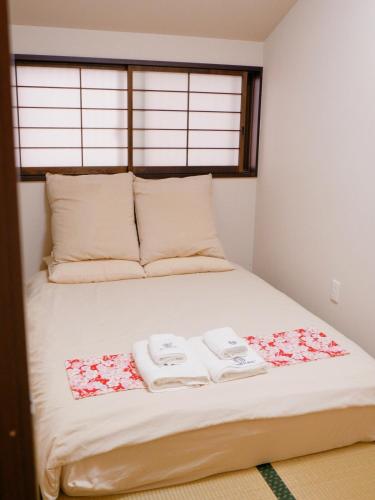 a bedroom with a bed with two towels on it at Sannö Sakura House Japanese Entire House with 2 Bedrooms &Near Tennoji 7 min Walk &Near Public Transport Near Abeno Harukas &Direct to Namba Kansai Airport and USJ in Osaka