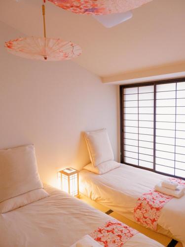 a room with two beds and a window at Sannö Sakura House Japanese Entire House with 2 Bedrooms &Near Tennoji 7 min Walk &Near Public Transport Near Abeno Harukas &Direct to Namba Kansai Airport and USJ in Osaka