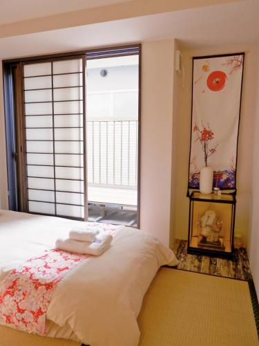 a bedroom with a bed with a large window at Sannö Sakura House Japanese Entire House with 2 Bedrooms &Near Tennoji 7 min Walk &Near Public Transport Near Abeno Harukas &Direct to Namba Kansai Airport and USJ in Osaka