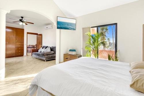 - une chambre blanche avec un lit et un canapé dans l'établissement La Posada Alberca privada y playa cercana, à La Paz