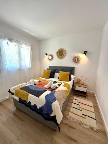 - une chambre dotée d'un grand lit avec des draps jaunes et bleus dans l'établissement Cala Rossa by Saraï, Apt T2 4 personnes, dans Résidence hôtelière avec piscine, à Lecci