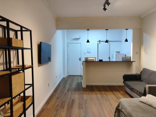 a living room with a couch and a kitchen at Studio SDU Aeroporto VLT Metrô Cinelândia in Rio de Janeiro
