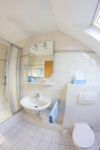 a white bathroom with a sink and a toilet at Hotel Restaurant Krone in Nassau