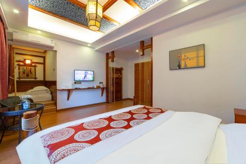 a bedroom with a large bed and a dining room at 张家界星河清梦民俗客栈 in Zhangjiajie