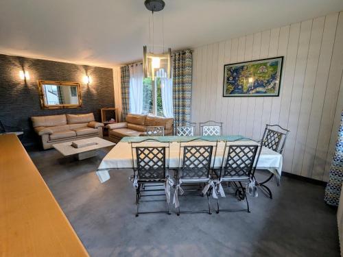 un salon avec une table et des chaises dans l'établissement Gîte à Gérardmer : sauna, terrasse, proche lac et stations de ski - FR-1-589-669, à Gérardmer